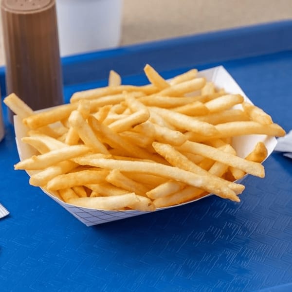 A white paper tray filled with golden-brown french fries sits on a blue textured tray.