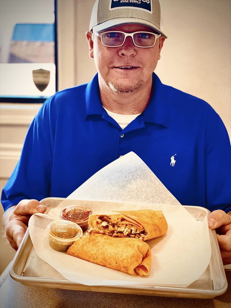 A guest holding a tray with one of our burritos
